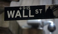 A Wall Street sign is pictured in the rain outside the New York Stock Exchange